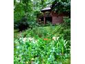 A picturesque wooded yard surrounds a cozy log home with a beautiful brick foundation and an upper deck at 5912 Potter S Rd, Waxhaw, NC 28173