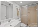 Bathroom with white cabinets, toilet, and sliding glass door shower at 7138 Stonington Ln, Charlotte, NC 28227