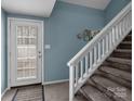 View of the stairway leading to the second story, with the front door to the left at 7138 Stonington Ln, Charlotte, NC 28227