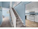 View of the carpeted stairway leading to the second story, and the kitchen through an archway at 7138 Stonington Ln, Charlotte, NC 28227