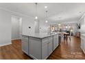 Open-concept kitchen with a large island, hardwood floors, and a view of the dining and living areas at 809 Cadence Park Pl, Fort Mill, SC 29708