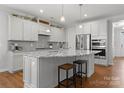 Bright and airy kitchen with stainless steel appliances, granite countertops, and hardwood floors at 809 Cadence Park Pl, Fort Mill, SC 29708