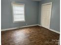 Bedroom showcasing hardwood floors, a window with blinds, and a closet at 821 S Oakland St, Gastonia, NC 28054