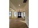 Inviting entryway features a stylish front door, chandelier, wood floors, and detailed trim work at 8827 Wingard Rd, Waxhaw, NC 28173