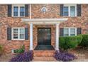 Charming brick home featuring a classic front entrance with black shutters and a well-manicured lawn at 912 Mcalway Rd, Charlotte, NC 28211