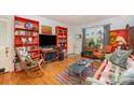 Inviting living room featuring colorful bookshelves, hardwood floors, and a unique glass coffee table at 912 Mcalway Rd # D, Charlotte, NC 28211