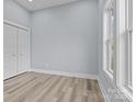 Bright bedroom with light wood floors, a built in closet, white trim, and a large window, creating a cozy feel at 913 Wilson W Lee Blvd, Statesville, NC 28677