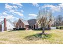Beautiful brick home featuring a mature tree and a well-manicured lawn at 1114 Setter Ln, Concord, NC 28025