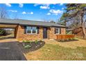 Charming single-story brick home with manicured landscaping, with a carport and well-maintained lawn at 114 Downing St, Troutman, NC 28166