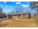 Charming single-story brick home with manicured landscaping and well-maintained lawn on a sunny day at 114 Downing St, Troutman, NC 28166