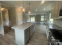Open-concept kitchen with a center island, stainless appliances, and sightlines into the living area at 11533 Valley Oaks Ln, Stanfield, NC 28163