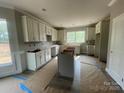 Spacious kitchen with light-colored cabinets, an island, and a bright window at 11533 Valley Oaks Ln, Stanfield, NC 28163