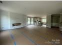 Open-concept living room featuring a fireplace and seamless flow into the modern kitchen at 11533 Valley Oaks Ln, Stanfield, NC 28163