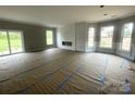 Bright living room with large windows, a decorative fireplace, and ample space for furnishings at 11533 Valley Oaks Ln, Stanfield, NC 28163