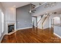 Open living room with a fireplace, hardwood floors, and staircase at 11609 Mersington Ln, Charlotte, NC 28277