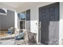 Inviting front porch with seating area, stylish gray door, and decorative stone accents at 12425 Larue Ln, Huntersville, NC 28078