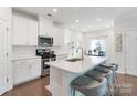 Bright kitchen featuring white cabinetry, stainless steel appliances, and a spacious island with seating at 12425 Larue Ln, Huntersville, NC 28078