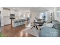 Open-concept living room and kitchen with hardwood floors and modern furnishings at 12425 Larue Ln, Huntersville, NC 28078