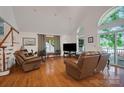 Bright living room with hardwood floors, high vaulted ceiling and lots of natural light from the surrounding windows at 136 Nicks Rd, Norwood, NC 28128