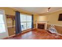 Bright living room featuring wood floors and a brick fireplace at 14440 W Highway 55 Hwy, Blacksburg, SC 29702