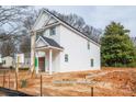 Two-story home boasts a white exterior, covered porch, and attached one car garage at 166 S Sycamore St, Mooresville, NC 28115
