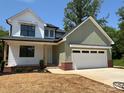 Charming two-story home with white and green siding, a two-car garage, and a well-manicured front yard at 1906 Maius Dr, Conover, NC 28613