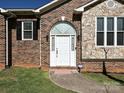 Inviting entryway with a white front door, brick accents, and decorative sidelights at 2339 Perry Rd, Denver, NC 28037