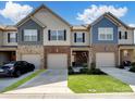 Townhome featuring a brick facade, attached garages, and a well-manicured front yard at 3441 Scottish Fern Ln, Indian Land, SC 29707