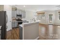 Stylish kitchen with gray cabinets, stainless steel appliances, and a breakfast bar at 3441 Scottish Fern Ln, Indian Land, SC 29707