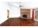 Spacious living room showcases hardwood floors, brick fireplace, and modern lighting fixture at 5060 Post Oak Ln, Rock Hill, SC 29732