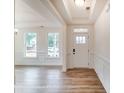 Bright entryway with white walls, wood floors, and natural light from the front door and surrounding windows at 5116 Heathland Dr # 76, Charlotte, NC 28215