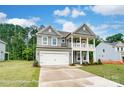 Charming two-story home boasts a covered balcony, attached two-car garage, and manicured lawn at 5116 Heathland Dr # 76, Charlotte, NC 28215