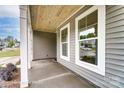 A view of the home's covered porch with beautiful wood ceiling and views from the large windows at 5116 Heathland Dr # 76, Charlotte, NC 28215