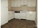 Well-lit kitchen featuring white cabinets, appliances, and updated flooring at 6354 Old Pineville Rd # A, Charlotte, NC 28217