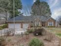 Well-maintained brick home with a three-car garage, mature landscaping, and inviting entrance at 805 Stack Rd, Monroe, NC 28112