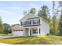 Traditional two-story home featuring a well-manicured lawn, attached garage, and welcoming front porch at 8455 Old Plank Rd, Charlotte, NC 28216