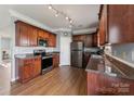 Well-lit kitchen featuring stainless steel appliances, granite countertops, and wooden cabinets at 1102 Less Traveled Trl, Indian Trail, NC 28079