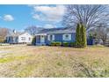 Charming blue single-story home with a manicured lawn, white trim, and an American flag at 1205 Poston Cir, Gastonia, NC 28054