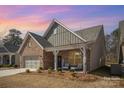 Beautiful brick home featuring a cozy front porch with seating, complemented by a well-maintained lawn at 1715 Rhynes Trl, Rock Hill, SC 29732