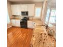 Well-appointed kitchen with granite countertops, white cabinets, and stainless steel appliances at 18845 Cloverstone Cir, Cornelius, NC 28031