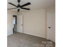 This airy bedroom features neutral carpeting and a contemporary ceiling fan at 2868 Oasis Ln, Charlotte, NC 28214