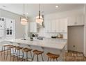 Bright, modern kitchen with island, sleek pendant lights, and stainless steel appliances at 3413 Holabird Ln # 10, Charlotte, NC 28208