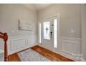 Bright foyer features hardwood floors, wainscoting, and a decorative glass front door at 423 Castlebury Ct, Clover, SC 29710