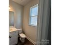 Clean, well-lit powder room with white fixtures, vanity, and a window at 4254 Black Ct # 170, Harrisburg, NC 28075