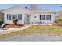 Cozy single-story home with a well-maintained lawn and inviting front porch with rocking chairs at 4450 Flowes Store Rd, Concord, NC 28025