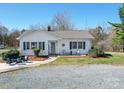 Beautiful one-story house with well-manicured front yard, walkway and outdoor seating at 4450 Flowes Store Rd, Concord, NC 28025