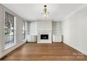 Bright living room with fireplace, custom bookshelves, and hardwood floors at 6141 Creft Cir, Indian Trail, NC 28079