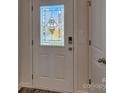 Front door features decorative glass, modern lock system and white trim at 9534 Maltese Dr, Gastonia, NC 28056