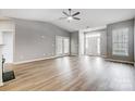 Bright living room with wood floors, vaulted ceiling, and double doors leading to a patio at 10011 Forest View Ln, Charlotte, NC 28213