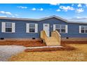 Charming exterior of a blue manufactured home featuring a newly built porch and white trim at 114 Hallmark Estates Dr, Statesville, NC 28625